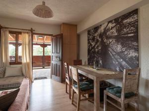 - une salle à manger avec une table et des chaises en bois dans l'établissement Traditional chalet in Livadi, à Kalívia