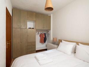 sypialnia z białym łóżkiem i drewnianymi szafkami w obiekcie Traditional chalet in Livadi w mieście Kalívia