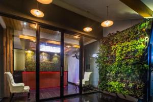 un vestíbulo con una pared verde y una puerta de cristal en Landmark Patong Hotel, en Patong Beach