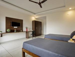 a hotel room with two beds and a tv at Wandr Scorpious - Manyata tech park in Bangalore