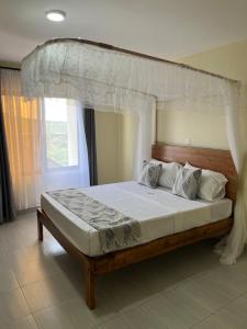 a bedroom with a bed with a canopy at THE AVID HOTEL in Voi