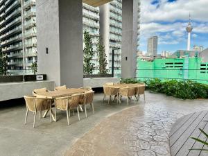 eine Terrasse mit Tischen und Stühlen auf einem Gebäude in der Unterkunft Axon Residence By Luxury Suites in Kuala Lumpur