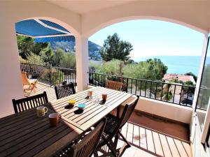 een veranda met een houten tafel en stoelen op een balkon bij Casa Roses, 4 dormitorios, 8 personas - ES-258-91 in Roses