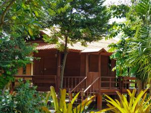 Ban Song (1)にあるบ้านสวนเปรมณัฐตราの森の中のポーチ付木造家屋