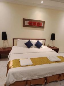 a bedroom with a large bed with two pillows on it at بوابة الريادة in Ar Riḩāb