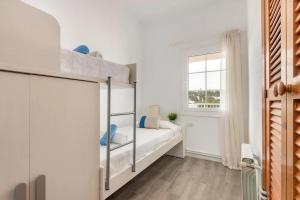 a bedroom with a bunk bed with a window at Ca n'Ernest in Cala Galdana