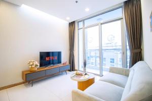 a living room with a couch and a tv at Raddison Luxury Apart-Landmark 81 Area &Great Park in Ho Chi Minh City