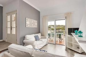 a living room with a white couch and a television at Ca n'Ernest in Cala Galdana