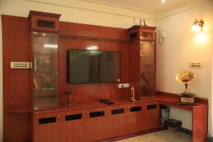 a living room with a flat screen tv on a wall at Gs Gardenia Homestay in Madurai