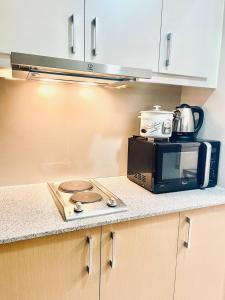 a kitchen counter with a microwave and a toaster oven at Thompson Suites - 2 beds, Uptown Parksuites Tower 1 25F in Manila