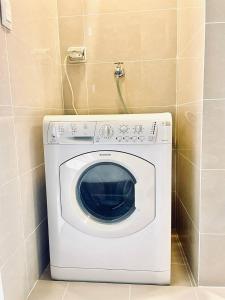 a washing machine in a corner of a bathroom at Thompson Suites - 2 beds, Uptown Parksuites Tower 1 25F in Manila