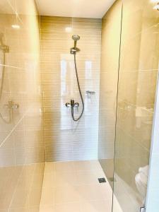 a bathroom with a shower with a glass door at Thompson Suites - 2 beds, Uptown Parksuites Tower 1 25F in Manila