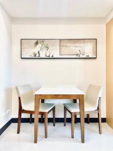 a dining room with a table and two chairs at Thompson Suites - 2 beds, Uptown Parksuites Tower 1 25F in Manila