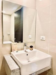 a bathroom with a white sink and a mirror at Thompson Suites - 2 beds, Uptown Parksuites Tower 1 25F in Manila