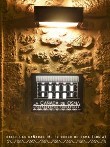 una señal en el costado de una pared de ladrillo en Apartamentos LA CAÑADA DE OSMA en El Burgo de Osma