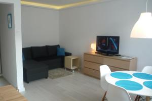 a living room with a couch and a table with a tv at Mieszkanie Przy Plaży in Gdańsk