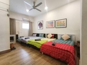 a bedroom with two beds and a ceiling fan at Cheerful 6BR Town House @ Geortown for 5-14pax by Cohans in George Town