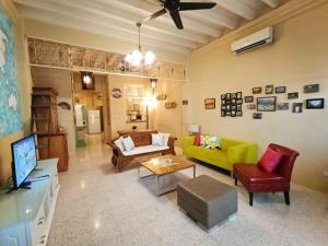 a living room with a yellow couch and chairs at Cheerful 6BR Town House @ Geortown for 5-14pax by Cohans in George Town