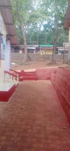 a row of red benches on a brick sidewalk at Ashirwad Cottage in Matheran
