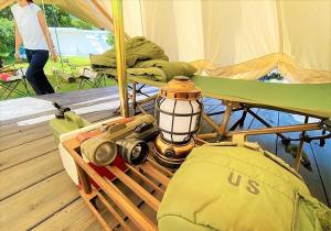 ein Zelt mit einer Laterne und einer Kamera auf einem Deck in der Unterkunft Katsuyama Basecamp - Camp - Vacation STAY 42349v in Yamanuha