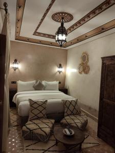 una camera con letto, tavolo e sedie di Riad Touhfa Kasbah Marrakech a Marrakech