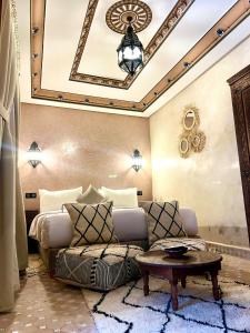 una camera con letto, divano e tavolo di Riad Touhfa Kasbah Marrakech a Marrakech