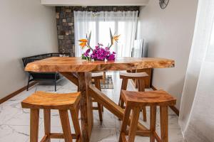 uma mesa de madeira com cadeiras e flores em cima em Laolabaone em La Gaulette