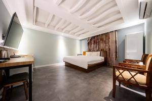 1 dormitorio con cama blanca, escritorio y escritorio en Hotel New Evergreen en Mokpo