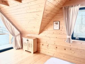 a bedroom with wooden walls and curtains in a room at Dom Bio - Unique Ski Chalet, Białka Tatrzańska, Slovakia, Zakopane in Białka Tatrzańska