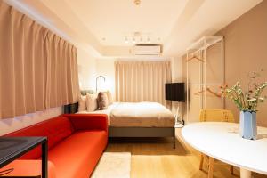 uma sala de estar com um sofá vermelho e uma cama em Section L Residence Ginza em Tóquio