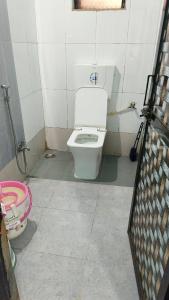 a bathroom with a white toilet in a room at Ashirwad Cottage in Matheran