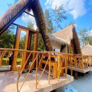 a house with a thatched roof and a balcony at BALI OF LIWA LAGOON BAR & BEACH RESORT in San Felipe