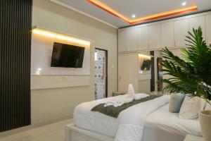 a bedroom with two beds and a tv on the wall at Bali Village Villa in Perean