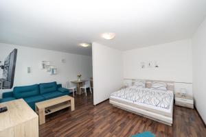 uma sala de estar com uma cama e um sofá em Penzion Bludička em Litomysl