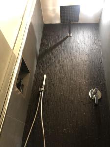 La salle de bains est pourvue d'une douche à l'italienne et d'un sol noir. dans l'établissement VESUCHARME SUITE Luxury Room, à Naples