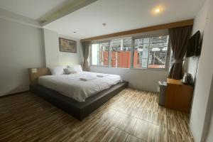 1 dormitorio con cama y ventana en Landmark Patong Hotel, en Patong Beach
