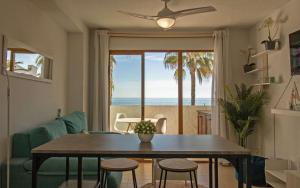 Sala de estar con mesa y vistas al océano en PRIMERA LINEA Playa Romana Frontal al Mar ALBERT VILLAS en Alcocéber