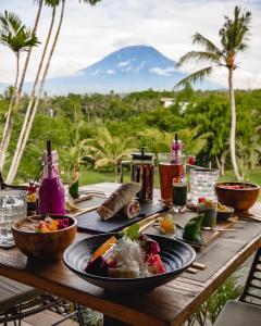 a wooden table with a plate of food on it at Balidroomvilla's in Karangasem