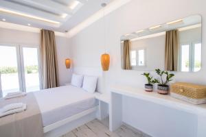 a white bedroom with a bed and a mirror at Depis Edem private villas naxos in Plaka