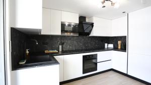 una cocina con armarios blancos y encimeras negras en Bel appartement T3 à louer, en Marsella