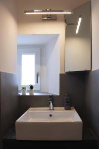 La salle de bains est pourvue d'un lavabo blanc et d'un miroir. dans l'établissement VESUCHARME SUITE Luxury Room, à Naples