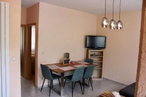 a dining room with a table and chairs and a tv at Ferienwohnung Amsel in Rheinsberg