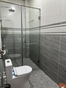 een badkamer met een toilet en een glazen douche bij Thien Phuc Hotel in Ba Tri