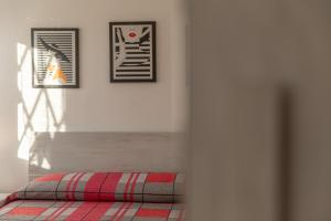 a bedroom with a bed with two pictures on the wall at White Angel in Castelnuovo del Garda