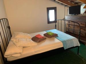 Una cama pequeña con dos toallas encima. en Antigua Aljibe, en Espera