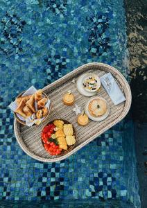 un vassoio di cibo su un tavolo in piscina di Kula Kara Private Villas a Uluwatu