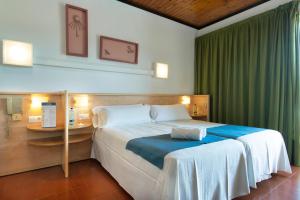 a bedroom with a large bed and a desk at Hotel Xaine Park in Lloret de Mar