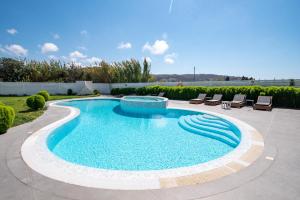 a swimming pool with two lounge chairs at Depis Edem luxury villas naxos in Plaka