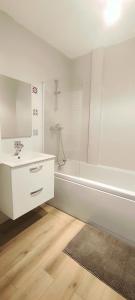 een witte badkamer met een wastafel en een douche bij Le Cocooning in Aureilhan