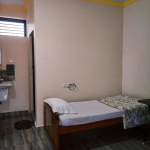 a small bedroom with a bed and a sink at Nellakki Homestay in Madikeri